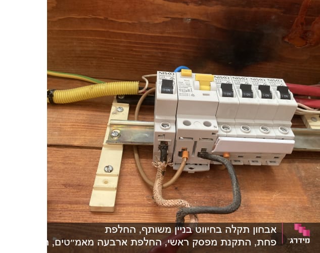 מפסקי חשמל מותקנים על לוח עץ עם חוטים מחוברים